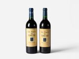 two bottles of wine sitting next to each other on a white surface