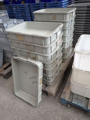 de nombreux conteneurs en plastique empilés sur des palettes dans un entrepôt
