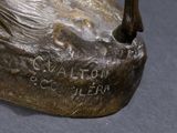 a bronze statue of a bird on a rock