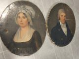 Deux portraits, celui d'un homme et celui d'une femme, sont représentés sur un sol carrelé.