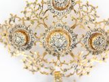 an image of a gold and diamond broochle on a white background