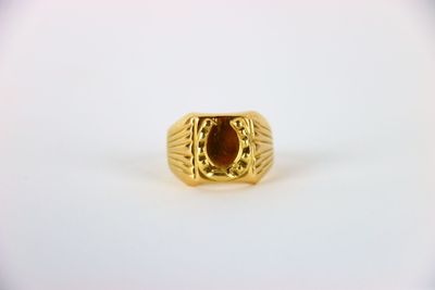 a close up of a gold ring with a red stone in it