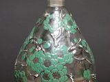 an image of a glass bottle with green flowers on it