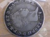 a silver coin with a picture of a dog on it