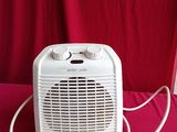 a white electric heater sitting on a red table