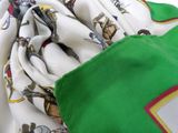 a close up of a green and white scarf with a picture of people on it