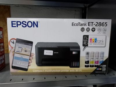 une boîte contenant une imprimante et un téléphone portable, posée sur l'étagère