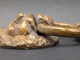 a statue of a man laying down on a rock