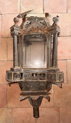 une petite lanterne en métal accrochée à un mur de briques