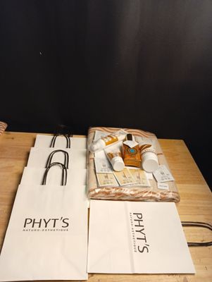 une table en bois sur laquelle se trouvent un sac de provisions et une paire de lunettes