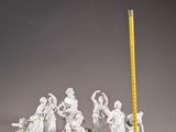 a statue of a group of people with a tape measure