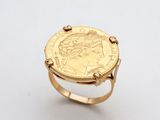 une bague en or surmontée d'une pièce de monnaie