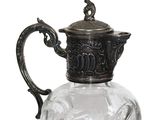 a glass pitcher with a metal handle on a white background