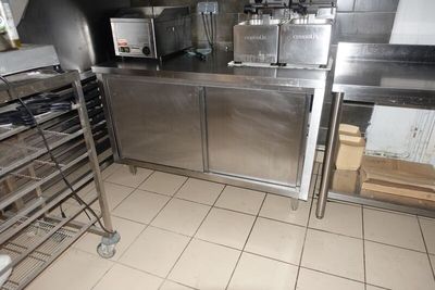 une grande cuisine en inox avec beaucoup de plans de travail