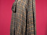plaid shirt on a mannequin stand against a red background