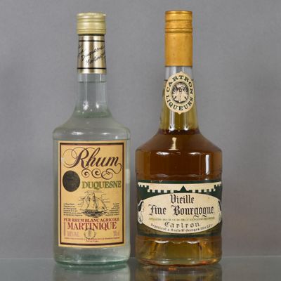 two bottles of rum and a bottle of liquor on a table