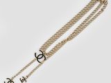 a gold chain bracelet with a black and white logo on it