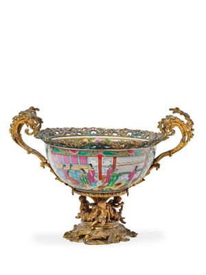 un bol richement décoré, posé sur un socle, sur une surface blanche