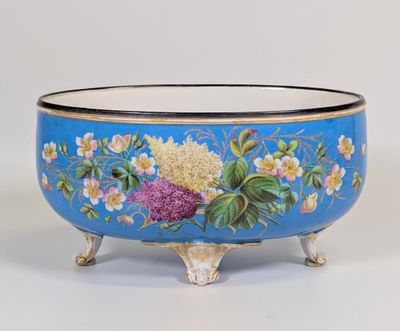 un bol bleu orné de fleurs peintes, posé sur un socle