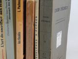 several books are stacked on top of each other on a white surface