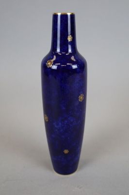 a blue vase with a gold decoration on it