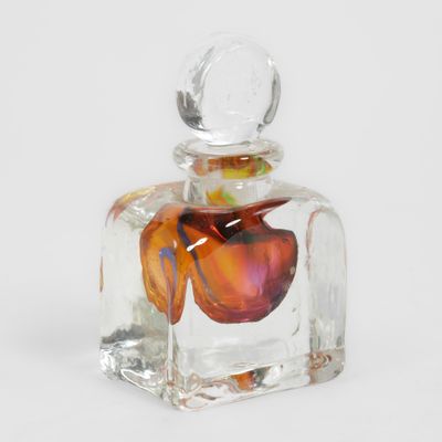 une petite bouteille en verre contenant une fleur