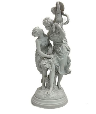 une statue représentant deux femmes assises sur un tabouret