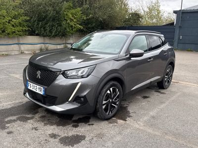un SUV gris garé sur un parking, avec des arbres en arrière-plan