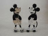 two figurines of mickey and minnie mouse on skateboards