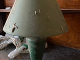 a green lamp that is on a table in a room