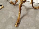 a gold table with a glass top and a candle on it