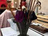 un vase contenant des parapluies et d'autres objets posés sur une table