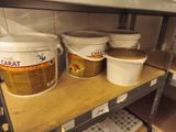 several buckets of food on a shelf in a store