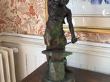 a bronze statue of a man holding a hammer on a table