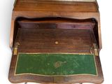 a small wooden desk with a green mat on top of it