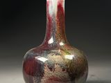 a red and white vase sitting on a table
