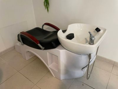 un lavabo blanc et une chaise noire dans une salle de bains