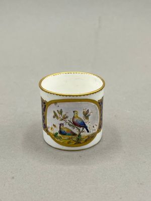 two small cups with birds painted on them sitting on a table