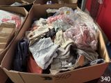 une boîte en carton pleine de vêtements posée sur le sol