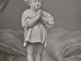 a statue of a little boy standing on a stool