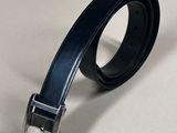black leather belt with a silver buckle on a white surface
