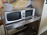 deux fours à micro-ondes posés sur une table en métal dans une cuisine
