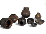 a group of small vases and bowls on a white surface