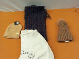 une couverture, un bonnet, une écharpe et des mitaines posés sur un lit