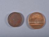 two coins that are sitting side by side on a table