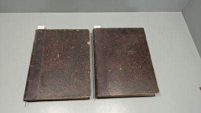 deux vieux livres posés sur une table blanche