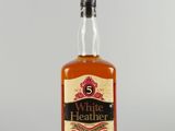 une bouteille de whisky « White Heather » posée sur une table
