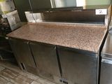 a counter with a sink and a refrigerator in the kitchen