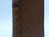un vieux livre posé sur une surface blanche avec un fond bleu