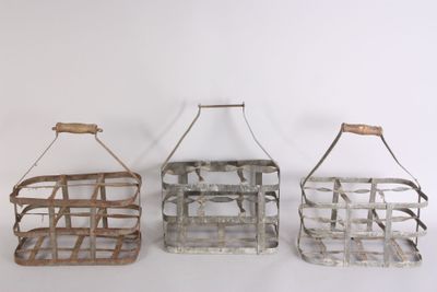 three metal baskets with handles hanging on a white wall